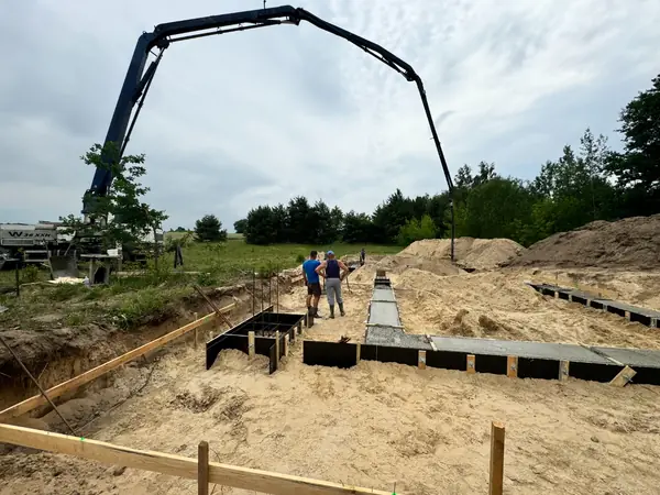 Pompa do betonu W36 XXH przy zalewaniu fundamentów domu jednorodzinnego — nadzór kierownika budowy nad robotami betoniarskimi